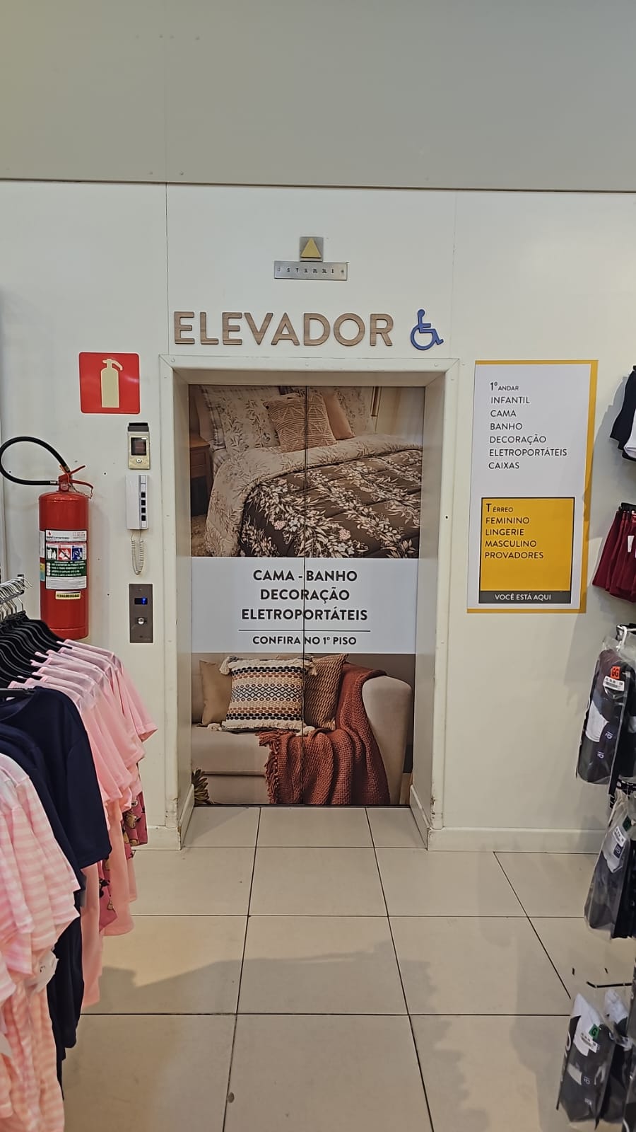 Elevador de loja adesivado com a comunicação dos setores do primeiro piso