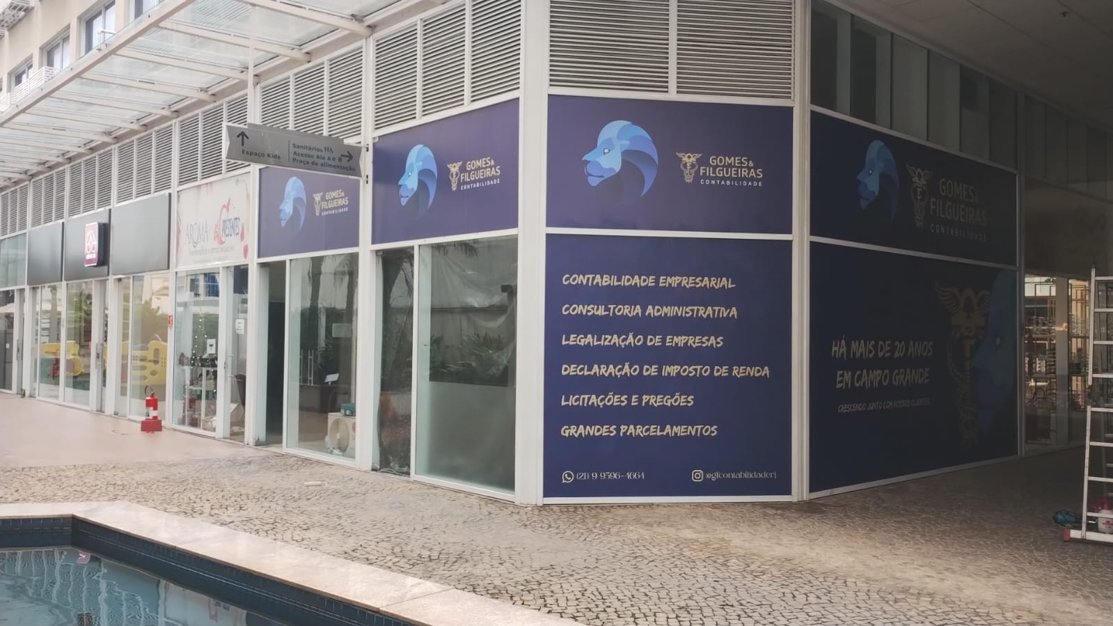 Fachada de escritório de contabilidade em galeria comercial, com comunicação visual em toda a esquina