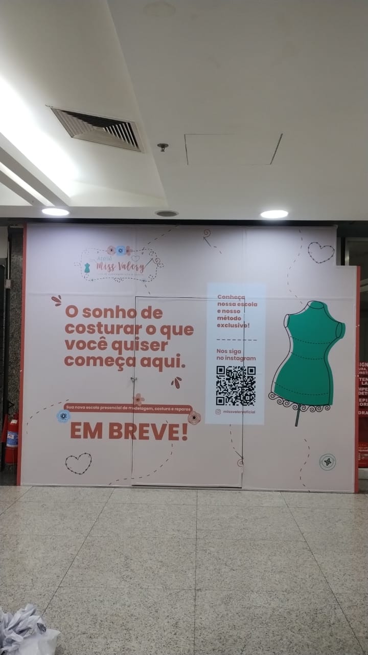 Tapume de loja em implantação anunciando a inauguração, com QR code para o Instagram