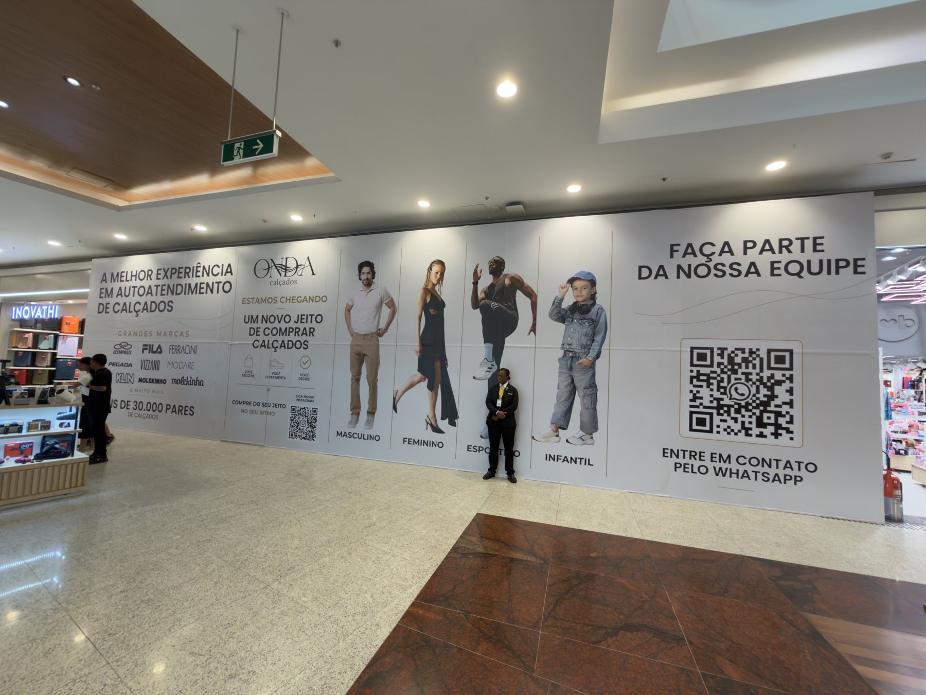 Tapume de 16 metros da ONDA Calçados instalado em corredor de shopping, anunciando a chegada da loja