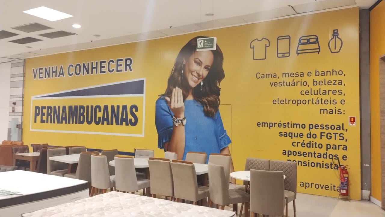 Tapume da Pernambucanas em loja de shopping, com a chamada Venha Conhecer